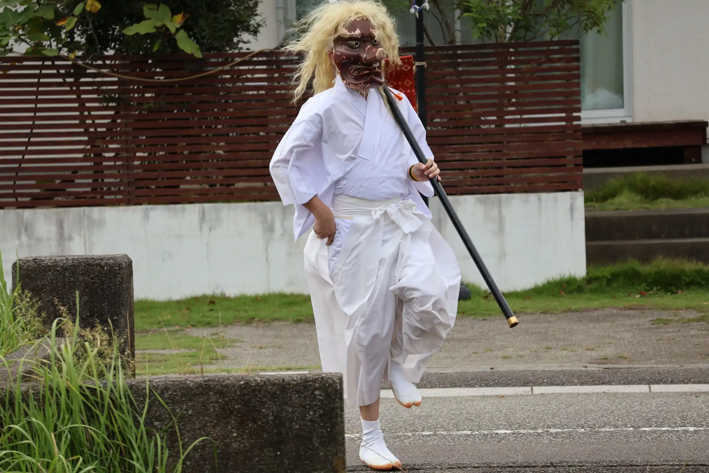 大御神社例大祭で役員に声をかけられ、ご機嫌にスキップする猿田彦
